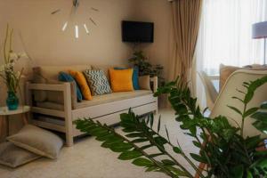 a living room with a couch and some plants at Remvi Deluxe Apartment 202 with Sea View in Karpathos