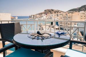 a table on a balcony with a view of the ocean at Remvi Deluxe Apartment 202 with Sea View in Karpathos