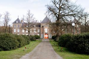 a large brick building with a red light in the doorway at B&B StudioLKE in Heeze