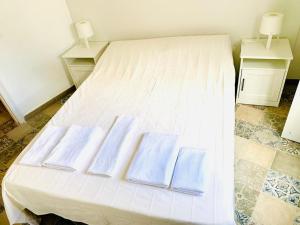 a white bed with three blue pillows on it at Efigenia playa/mar 3 in Valle Gran Rey