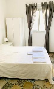 a white bed in a room with a window at Efigenia playa/mar 3 in Valle Gran Rey