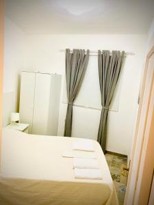a bedroom with a bed and a mirror and curtains at Efigenia playa/mar 3 in Valle Gran Rey