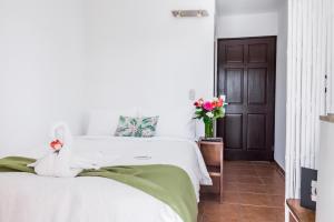 1 dormitorio con 1 cama con sábanas blancas y puerta en The Palms At Coco Beach, en Coco