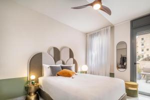 a bedroom with a large white bed and a ceiling fan at Mr. Agrippa - By TLV2GO in Jerusalem
