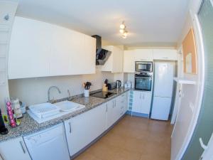 uma cozinha com armários brancos e um frigorífico branco em Immaculate 2-Bed Apartment in Pego em Pego