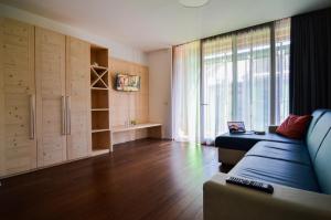 a living room with a couch and a large window at Komodo short stay apartments in Trento