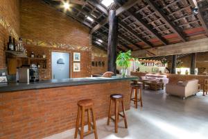 - un bar en briques dans un restaurant avec tabourets dans l'établissement Pousada Olho D'Água, à Bonito