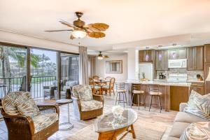 a living room and kitchen with a couch and chairs at Kauai Beach Villas D10 in Lihue