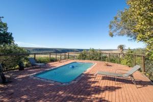 a swimming pool with two lounge chairs on a brick patio at Camp Acacia - Private Safari Lodge with Pool near Amakhala in Paterson