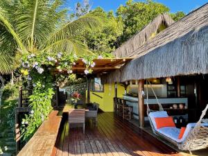 a porch of a resort with chairs and a hammock at Bahia Beach House in Praia do Espelho