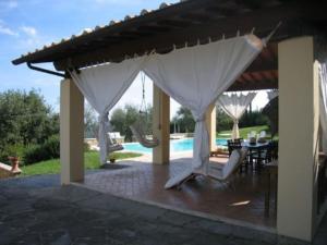 a patio with a table and chairs under a pavilion at Podere Belvedere - Villa with private swimming-pool by Charming Italy Tour in Carmignano