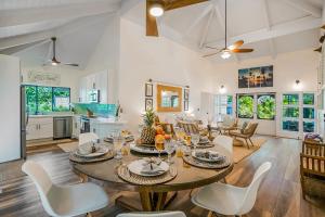 a dining room and living room with a table and chairs at Sea Turtle Cottage in Princeville