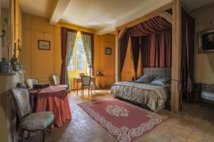 Schlafzimmer mit einem Bett, einem Tisch und Stühlen in der Unterkunft Chateau du Blanc Buisson in Saint-Pierre-du-Mesnil