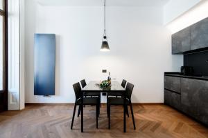 a dining room with a black table and chairs at Dome's Charme - The House Of Travelers in Como