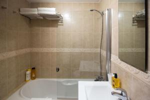 een badkamer met een bad, een wastafel en een douche bij Lanuza ✪ Garaje. A 5 minutos andando del Reloj de Formigal in Formigal