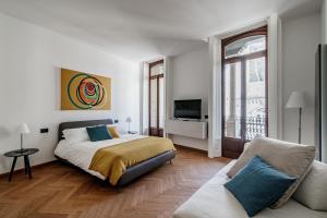 a white bedroom with a bed and a couch at Dome's Charme - The House Of Travelers in Como