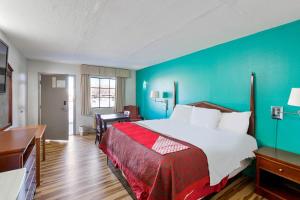 a hotel room with a bed and a blue wall at Hotel O Columbia Downtown near I-65 in Columbia