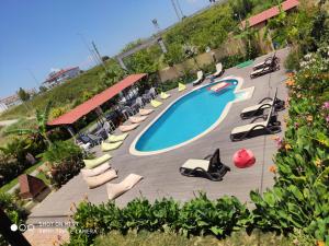 a swimming pool with chaise lounges and chairs at Nostalgia World OTEL in Kızılot
