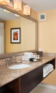 a bathroom with a sink and a mirror at The Branson Hillside Hotel in Branson