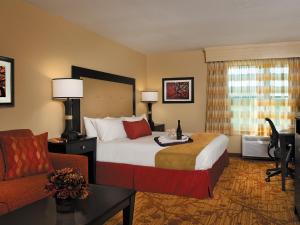 a hotel room with a bed and a desk and a chair at The Branson Hillside Hotel in Branson