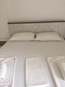 a white bed with two white pillows on it at Guest house Plazhi Dhermi in Dhërmi