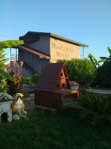 a dog sitting in the grass in front of a house at Nostalgia World OTEL in Kızılot