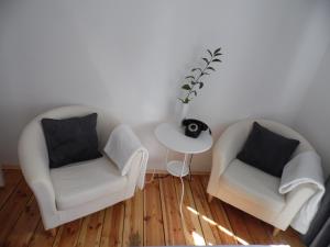 ソポトにあるKierunek Sopot Apartament POMORSKIのリビングルーム(椅子2脚、テーブル付)