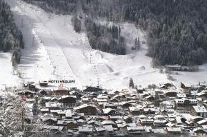 une petite ville dans la neige avec une piste de ski dans l'établissement Hotel L'Equipe, à Morzine