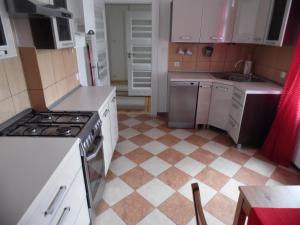 kuchnia z kuchenką i podłogą wyłożoną kafelkami w obiekcie Kierunek Sopot Apartament POMORSKI w mieście Sopot