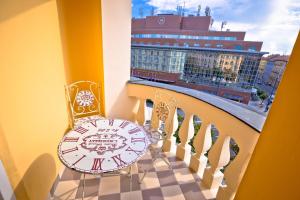 a clock on a balcony with a view of a city at Seven Stories Rooms, 4th Floor, no elevator in Zagreb