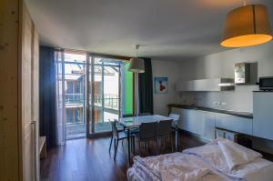 a kitchen and dining room with a table and a kitchen and a room at Komodo short stay apartments in Trento