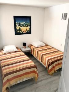 Cette chambre comprend deux lits et un tableau mural. dans l'établissement Résidence 4 etoiles Port Marine, à Sainte-Maxime