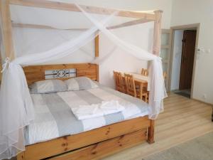 Schlafzimmer mit Himmelbett und weißen Vorhängen in der Unterkunft Apartament Pijarska in Nowy Sącz