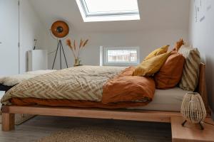 um quarto com uma cama com almofadas em Harbourskitchenhouse@sea em Bredene