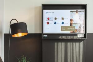 TV de pantalla plana sentada en un soporte junto a una lámpara en the niu Leo - Apartments, en Núremberg