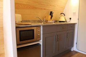 a kitchen with a sink and a microwave at The Honeybee Pod in Penrith