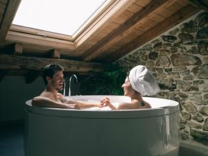 Hotel Nafarrola - Gastronomy & Wine في بيرميو: رجل وامرأة يجلسان في حوض الاستحمام