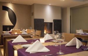 ein Restaurant mit einem Tisch mit Weingläsern und einem Kamin in der Unterkunft Hotel & Restaurant Zur Glocke in Höchstädt an der Donau