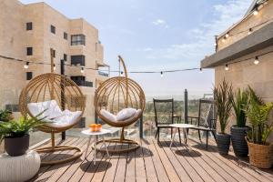 a patio with two chairs and tables and plants at Mr. Agrippa - By TLV2GO in Jerusalem +15 photos