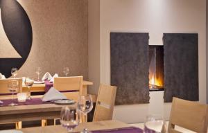 
a room with a table, chairs, and a fireplace at Hotel & Restaurant Zur Glocke in Höchstädt an der Donau
