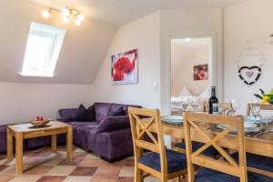 ein Wohnzimmer mit einem lila Sofa und einem Tisch in der Unterkunft Ferienwohnung Flocke in Sankt Peter-Ording