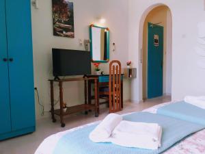 a bedroom with a television and a desk with a mirror at Medusa Apartments in Katelios
