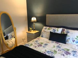 1 dormitorio con cama y espejo en Kilkeel Bungalow - the PERFECT place to stay en Kilkeel