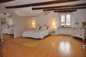 a large bedroom with two beds and two windows at Chambre baroque in Hagenthal-le-Bas