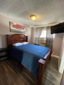 ein Schlafzimmer mit einem blauen Bett und einem Fenster in der Unterkunft LA Adventurer Hotel in Inglewood