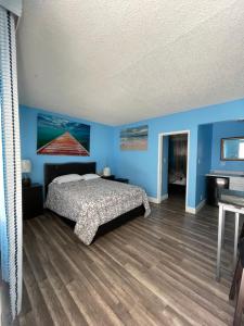 イングルウッドにあるLA Adventurer Hotelの青い壁のベッドルーム(ベッド1台、ピアノ付)