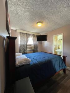 een slaapkamer met een blauw bed en een raam bij LA Adventurer Hotel in Inglewood
