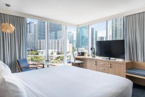 a hotel room with a large bed and a television at Novotel Miami Brickell in Miami