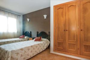 1 dormitorio con 2 camas y armario de madera en 0340 Nogal, en Jávea
