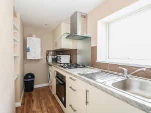 a kitchen with a sink and a stove at Oar Cottage in Mablethorpe